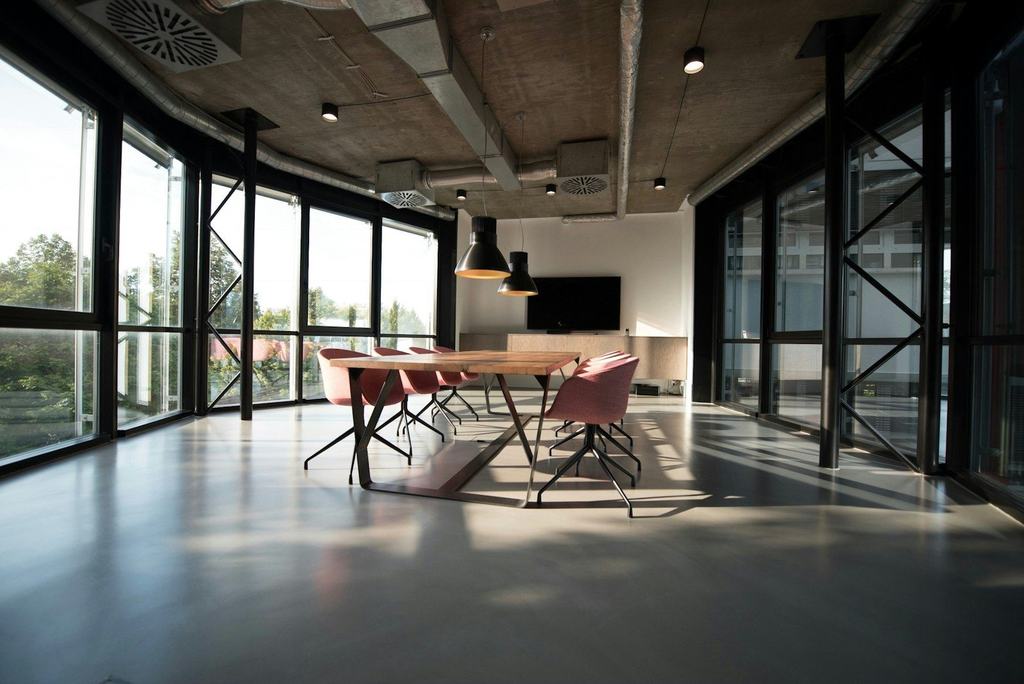 An empty modern office with glass walls and a meeting table